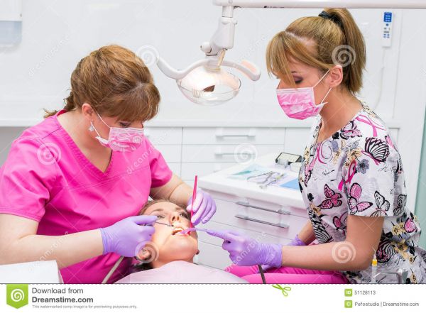 female dentists drilling teeth