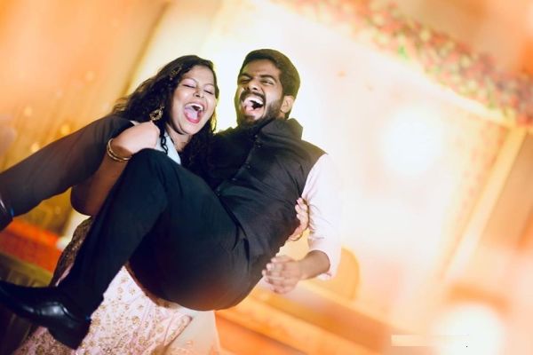 groom carrying bride over shoulder